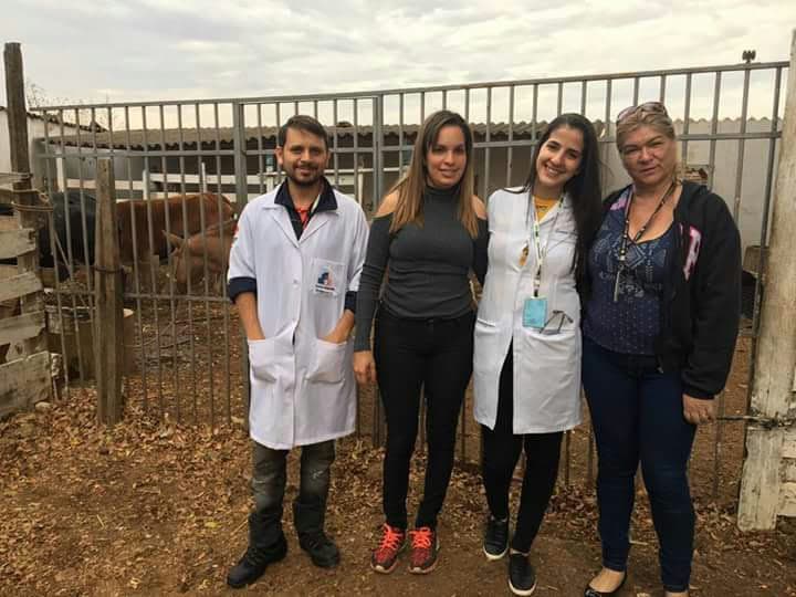 Daniela em visita técnica com equipe de jaleco em área rural