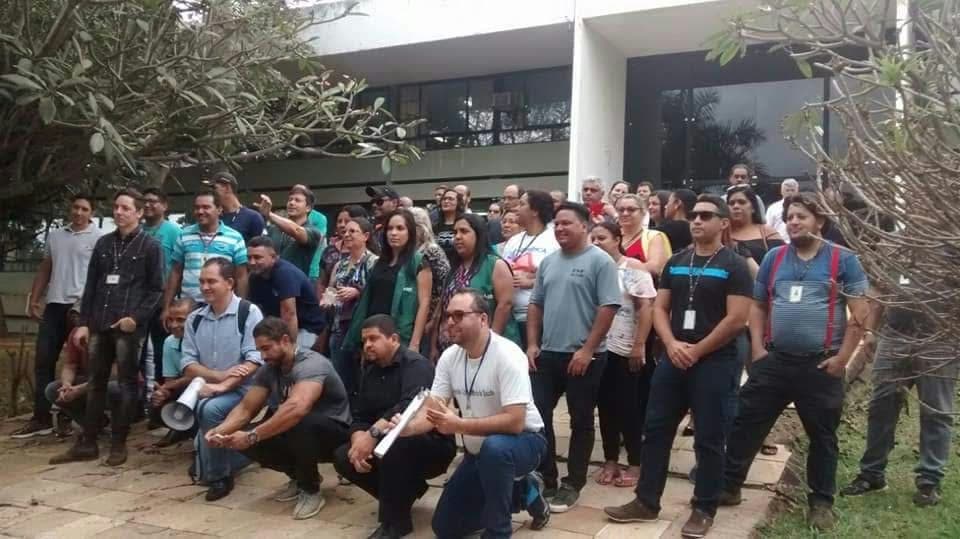 Grupo em frente a prédio público, assembleia ou reunião