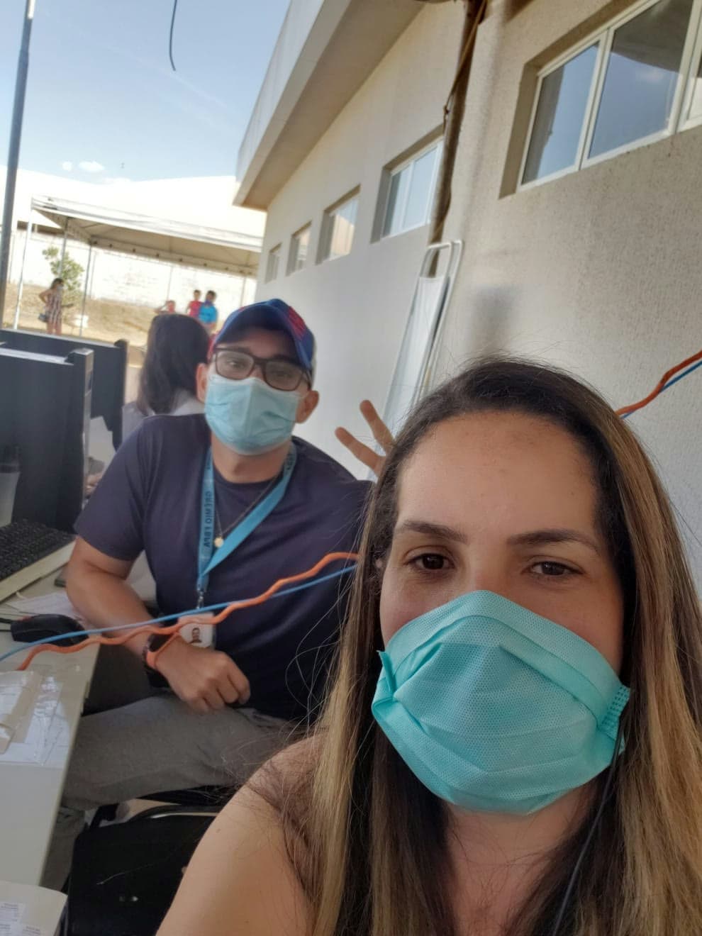 Daniela mascarada com colega no período de pandemia